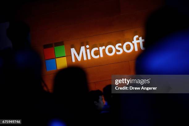 The Microsoft logo is illuminated on a wall during a Microsoft launch event to introduce the new Microsoft Surface laptop and Windows 10 S operating...