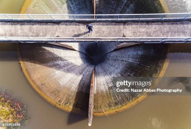 man standing on bridge that is build on top of lower huia dam. - barrage photos et images de collection