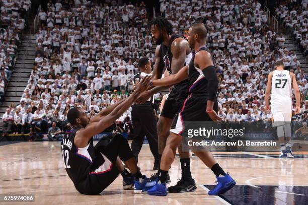 Chris Paul and DeAndre Jordan of the Los Angeles Clippers helps up Luc Richard Mbah a Moute of the Los Angeles Clippers during the game against the...