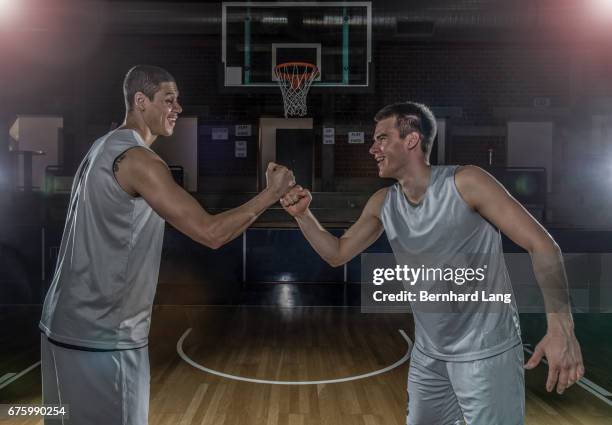 two basketball player fist bump each other - sportmannschaft stock pictures, royalty-free photos & images