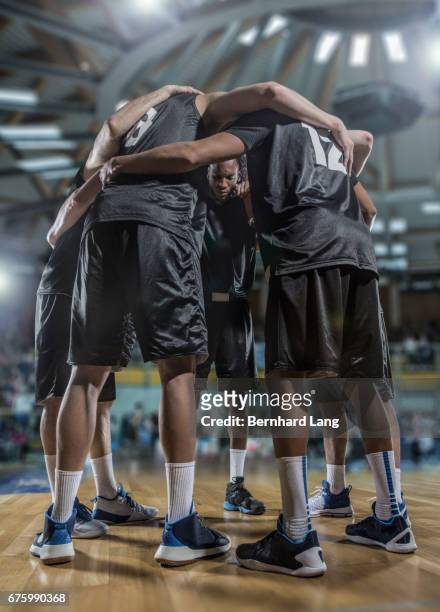 basketball team standing in cirlcle - equipo de baloncesto fotografías e imágenes de stock