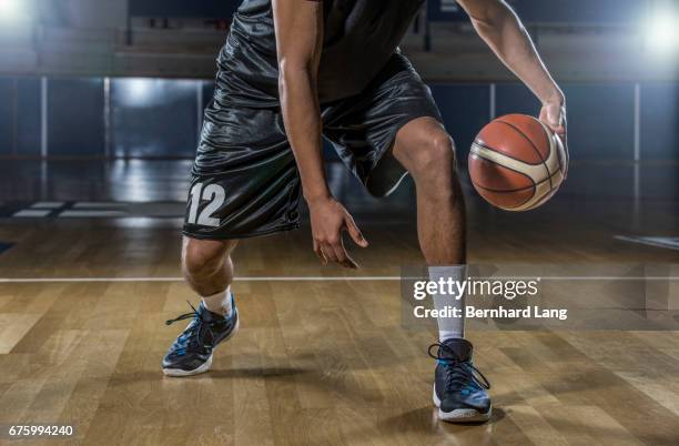 basketball player dribbling ball - dribbling basketball stock pictures, royalty-free photos & images