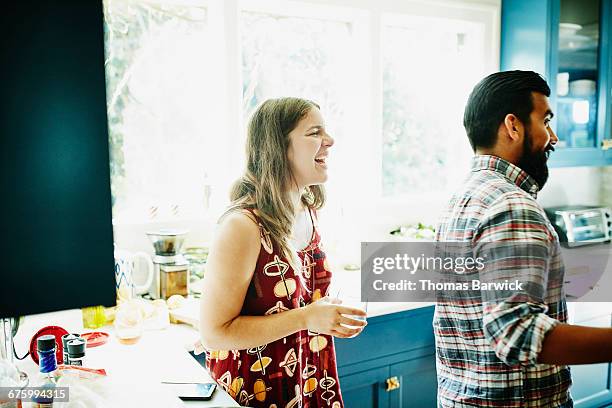 laughing woman hanging out with friends in kitchen - black hair dresser stock pictures, royalty-free photos & images