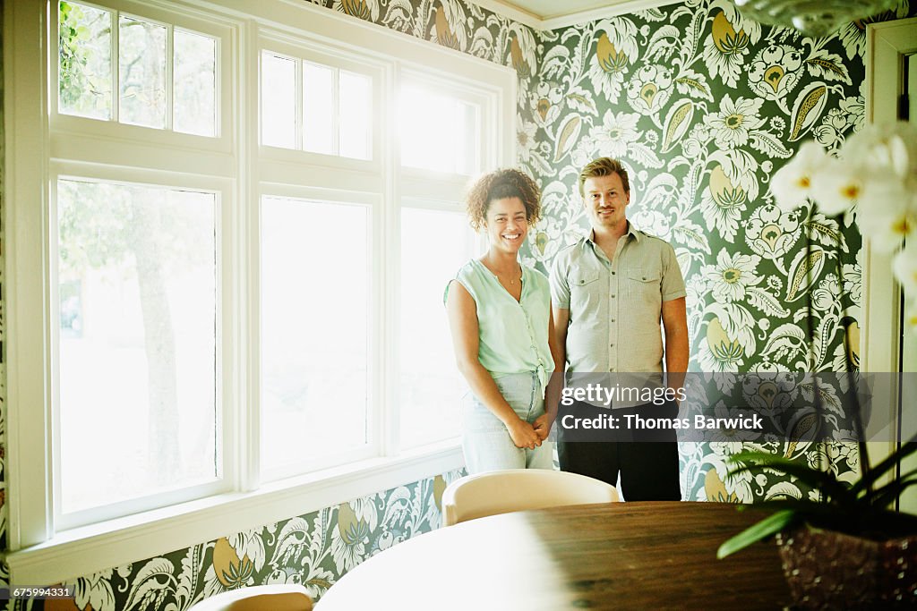 Portrait of smiling couple in dining room of home