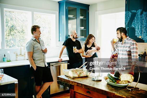 group of friends sharing drinks in kitchen - annual safeway feast of sharing stockfoto's en -beelden