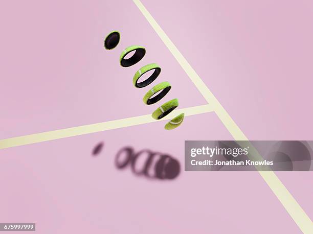 sliced tennis ball meets its shadow on court - tennis ball stock-fotos und bilder