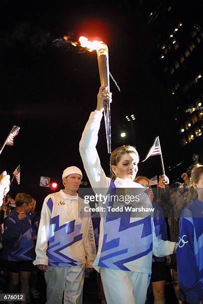 Torchbearer Teresa Earnhardt runs with the Olympic Flame December 5, 2001 during the 2002 Salt Lake Olympic Torch Relay in Ashville, North Carolina.