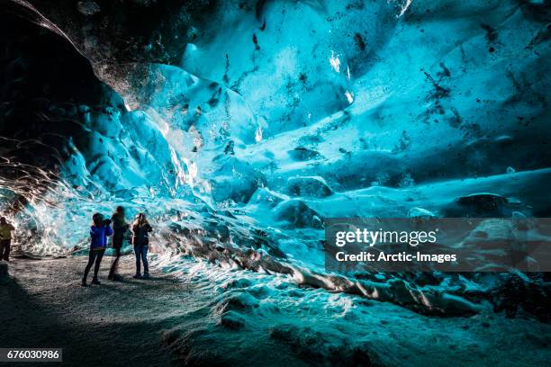 tourists in the crystal cave, breidamerkurjokull glacier, iceland - iceland glaciers stock pictures, royalty-free photos & images