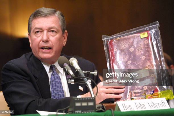 Attorney General John Ashcroft holds up a seized al Qaeda training manual as he testifies at a hearing on "Justice Department Oversight: Preserving...