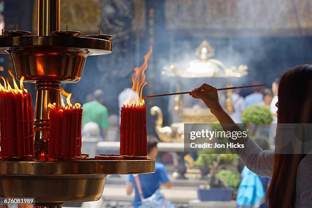 lighting a joss stick in longshan temple, taipei. - tao stock pictures, royalty-free photos & images