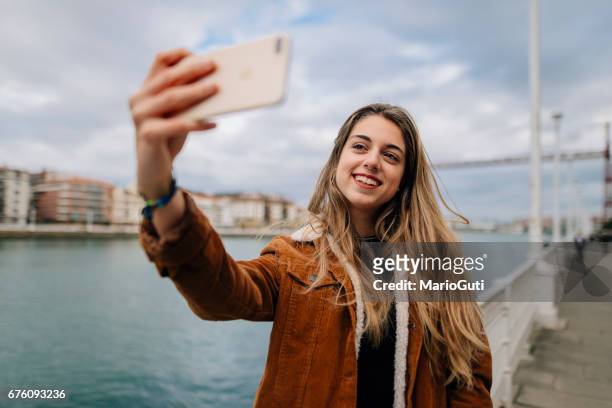 年輕女人採取自拍照 - dispositivo de información móvil 個照片及圖片檔