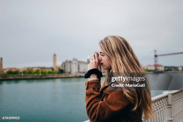 giovane donna che scatta una foto - oficio creativo foto e immagini stock