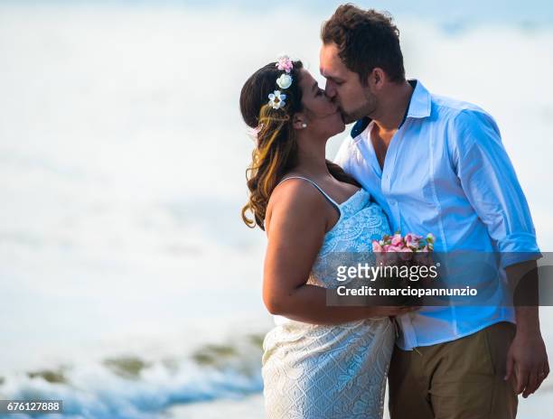 晴れた日のビーチで愛の若い新婚夫婦のカップル - movimento desfocado ストックフォトと画像