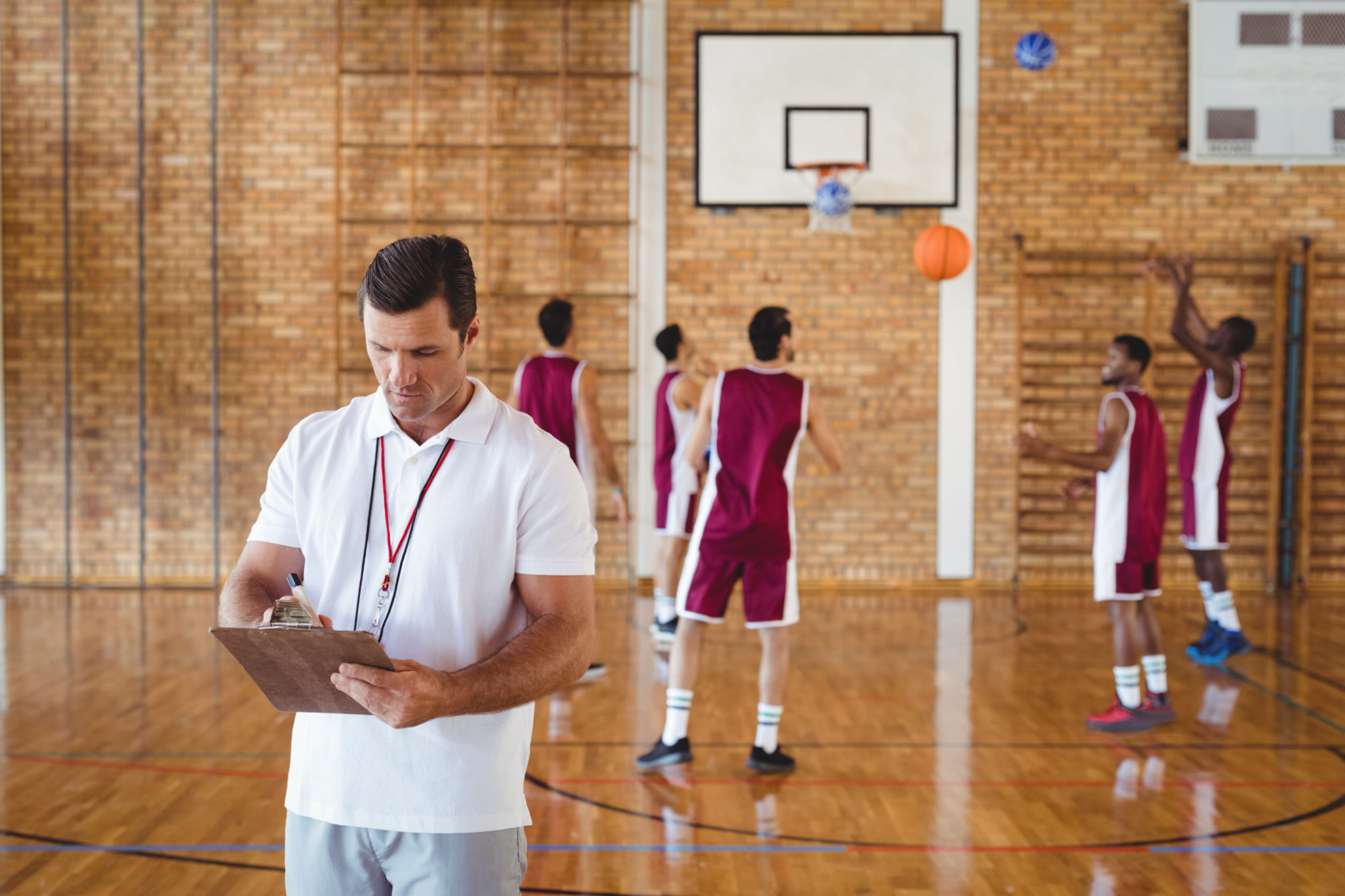 Basketball coach writing on clipboard Basketball coach writing on clipboard
