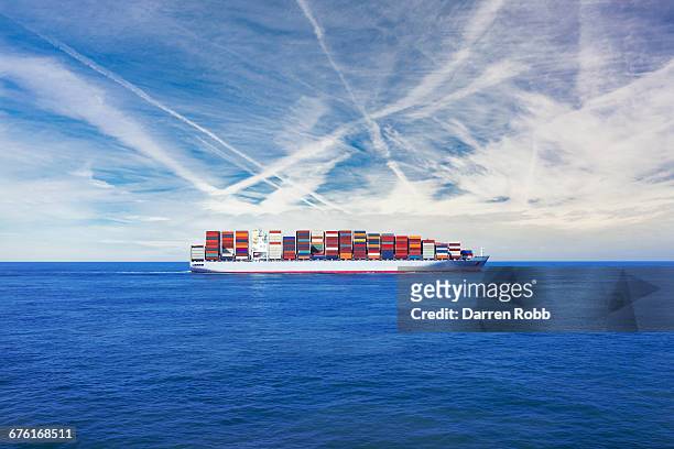cargo ship transporting containers across the sea - behållare bildbanksfoton och bilder