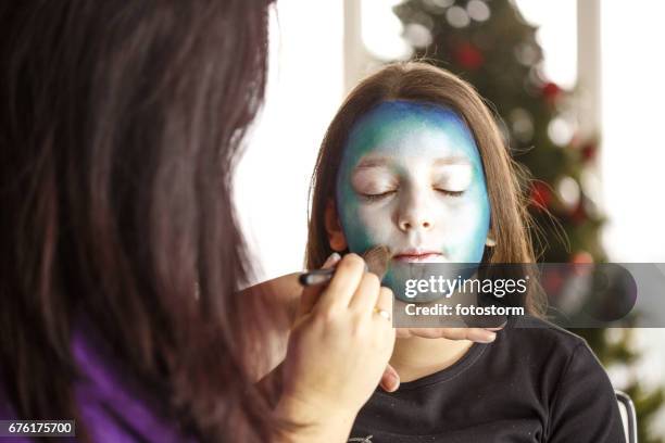 girl getting a face paint at christmas party - face painting stock pictures, royalty-free photos & images