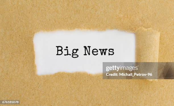 Text Big News appearing behind ripped brown paper.