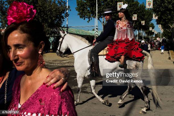 Participants in traditional dress ride on horseback as they enjoy the atmosphere at the Feria de Abril on May 1, 2017 in Seville, Spain. The Feria de...