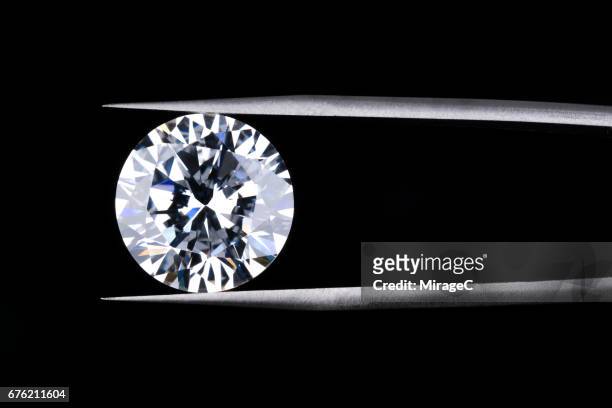 round diamond clamped by tweezers - diamond gemstone stock pictures, royalty-free photos & images