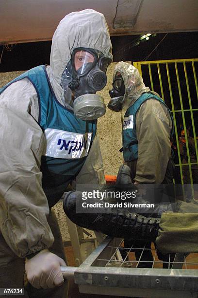 Wearing protective suits, Israeli army medics evacuate "contaminated victims" of a chemical warfare attack to a Tel Aviv hospital during a...