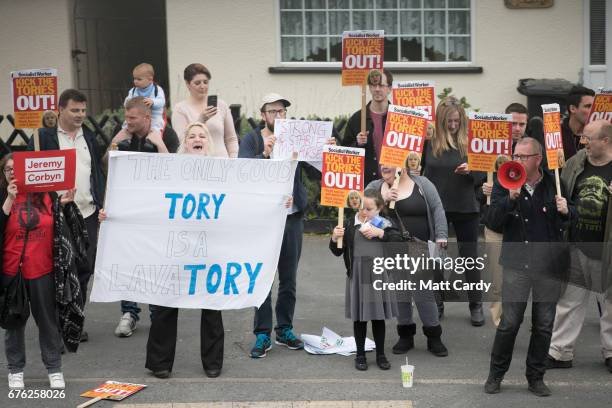 Protesters demonstrate outside as Britain's Prime Minister Theresa May addresses an audience of supporters during a campaign stop on May 2, 2017 in...