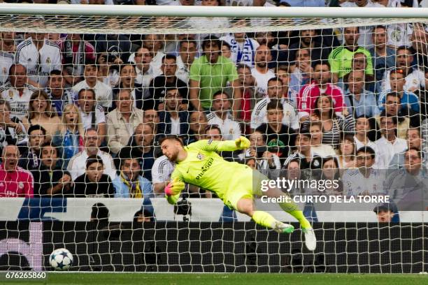 Atletico Madrid's Slovenian goalkeeper Jan Oblak misses to stop the ball after Real Madrid's Portuguese forward Cristiano Ronaldo scored during the...