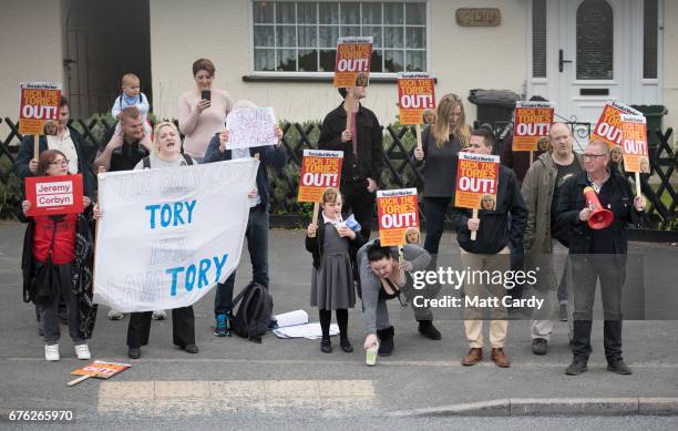 Protesters demonstrate outside as Britain's Prime Minister Theresa May addresses an audience of supporters during a campaign stop on May 2, 2017 in...