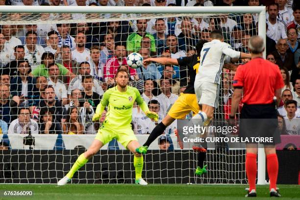 Atletico Madrid's Slovenian goalkeeper Jan Oblak eyes the ball as Real Madrid's Portuguese forward Cristiano Ronaldo heads to score during the UEFA...