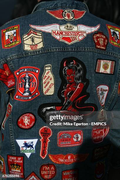 General view of the back of a Manchester United fan's Denim jacket with logos and badges on of Manchester United