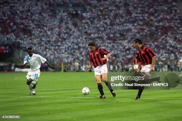 Milan's Daniele Massaro in action with teammate Marco van Basten , watched by Marseille's Jocelyn Angloma