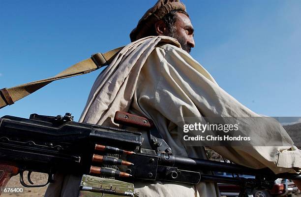 Northern Alliance soldier carries an M-60 machine gun December 7, 2001 in the Tora Bora area of Afghanistan. A standoff between Northern Alliance and...
