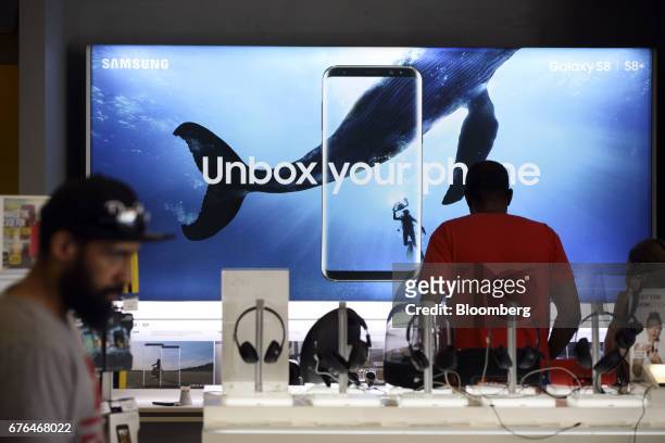 Customer browses Samsung Electronics Co. Galaxy mobile devices on display at a Sprint Corp. Store in Glendale, California, U.S., on Monday, April 24,...