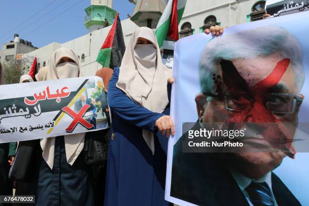 Palestinian woman hold signs as supporters of Hamas, Jihad Islamic and Al Ahrar movement gather to protest against President of the State of...