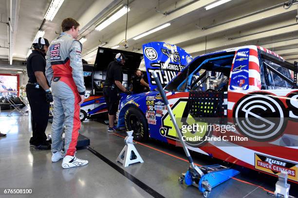 Travis Pastrana, driver of the Niece Motorsports Chevrolet, stands in the garage area during the NASCAR Camping World Truck Series test session at...