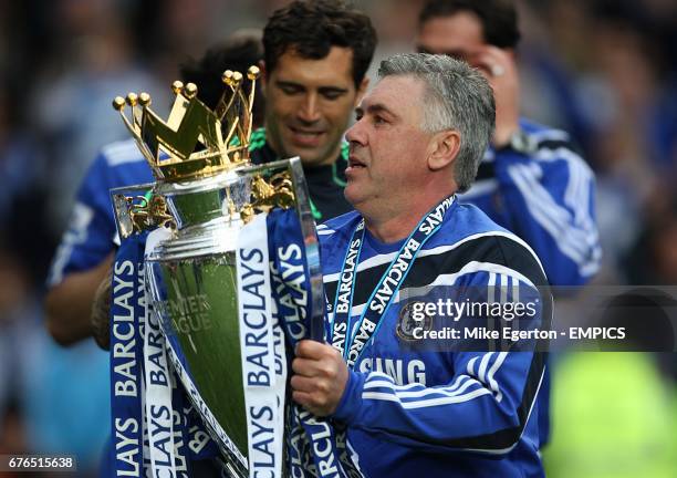 Chelsea manager Carlo Ancelotti celebrates with the Premier League trophy after the final whistle.