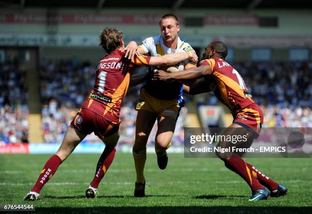 Warrington Wolves' Chris Hicks is tackled by Huddersfield Giants' Michael Lawrence and Brett Hodgson .