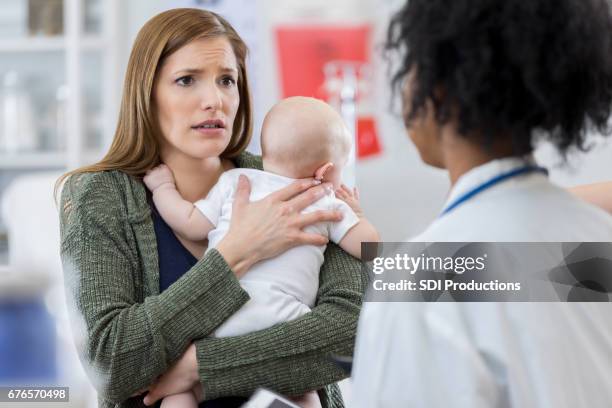 worried mom talks with her child's pediatrician - stressed parent stock pictures, royalty-free photos & images