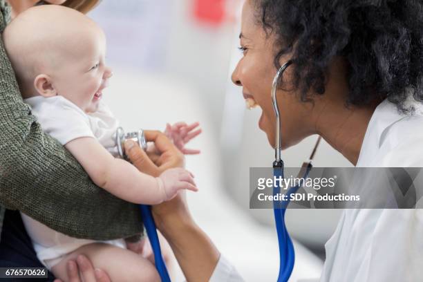 schattig baby smiles bij de kinderarts - cute nurses stockfoto's en -beelden