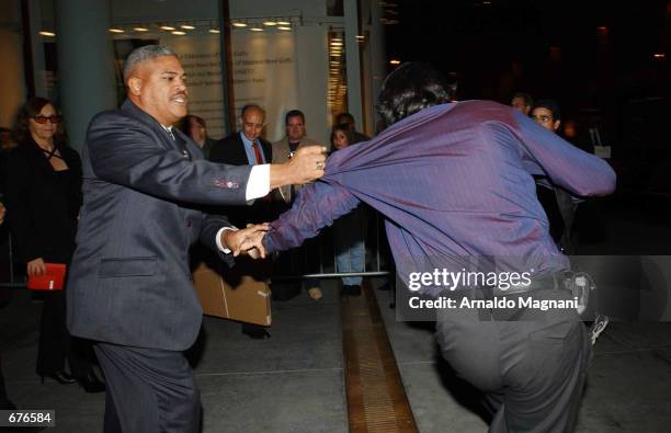 Paparazzi photographer Steve Sand scuffles with a security guard as Uma Thurman and famly leave the 2001 benefit auction for Tibet House U.S....