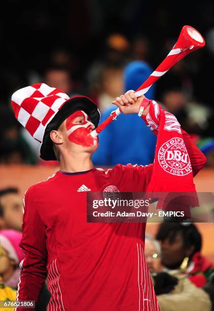 Denmark fan blows a vuvuzela in the stands prior to kick off