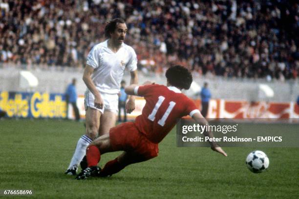 Liverpool's Graeme Souness slides in on Real Madrid's Uli Stielike despite the ball having already gone