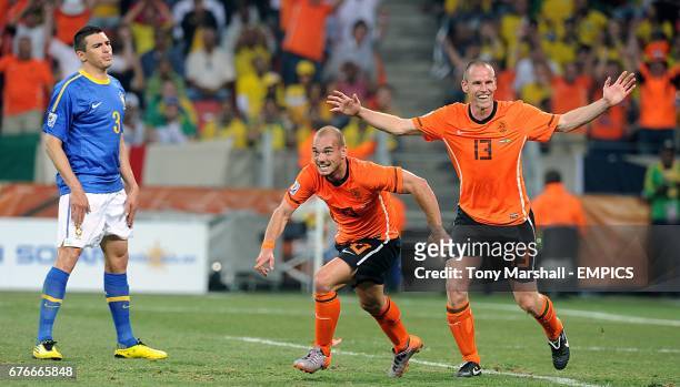 The Netherland's Wesley Sneijder celebrates with Andre Ooijer scoring his side's second goal of the game as Brazil's Lucio stands dejected