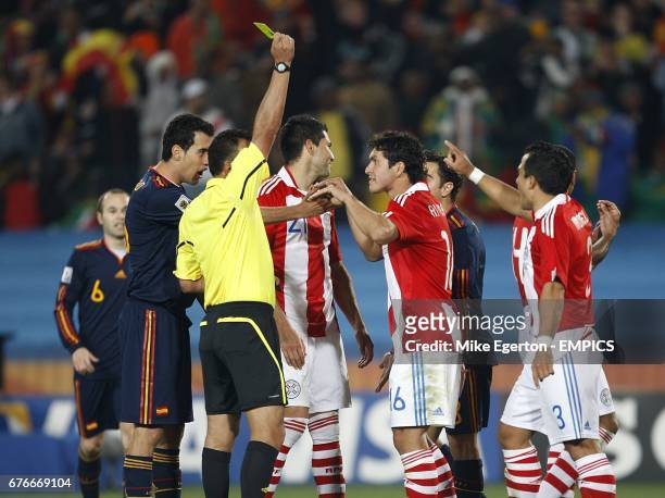 Referee Carlos Batres shows Paraguay's Antolin Alcaraz the yellow card.