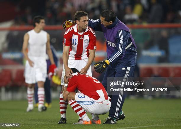 Paraguay's Aldo Bobadilla comforts team mates Jonathan Santana and Claudio Morel Rodriguez after the final whistle.