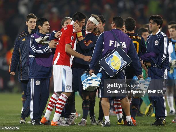 Paraguay's Oscar Cardozo is comforted by Spain's Sergio Ramos after the final whistle.