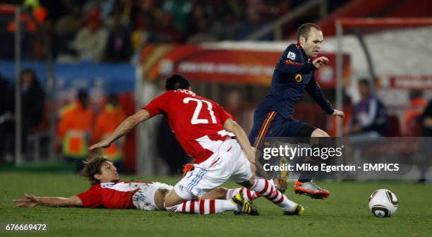 Spain's Andres Iniesta is tackled by Paraguay's Enrique Vera and Antolin Alcaraz