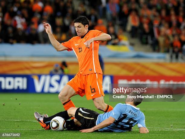 Uruguay's Diego Perez and Netherlands' Mark Van Bommel battle for the ball