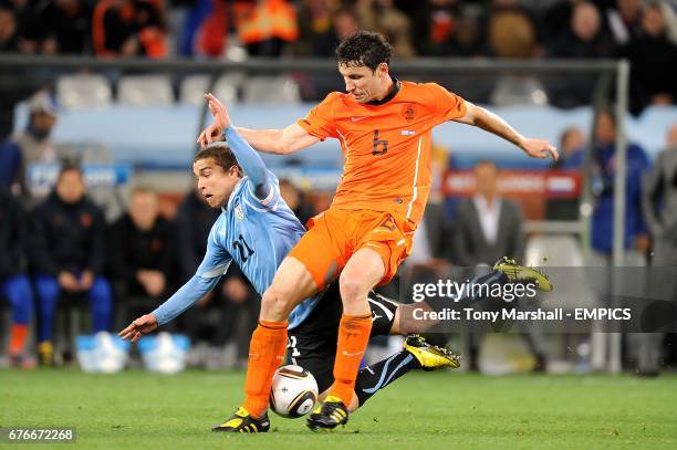 Uruguay's Sebastian Fernandez and Netherlands' Mark Van Bommel battle for the ball