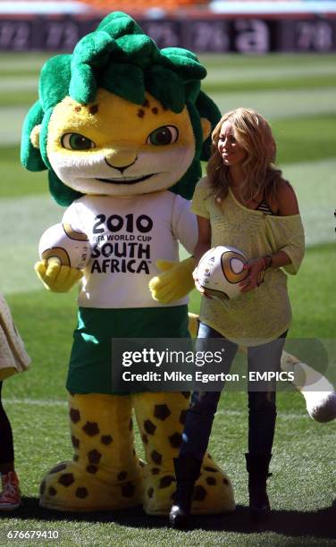 Singer Shakira holds the World Cup Final match ball inside Soccer City along with mascot Zakumi