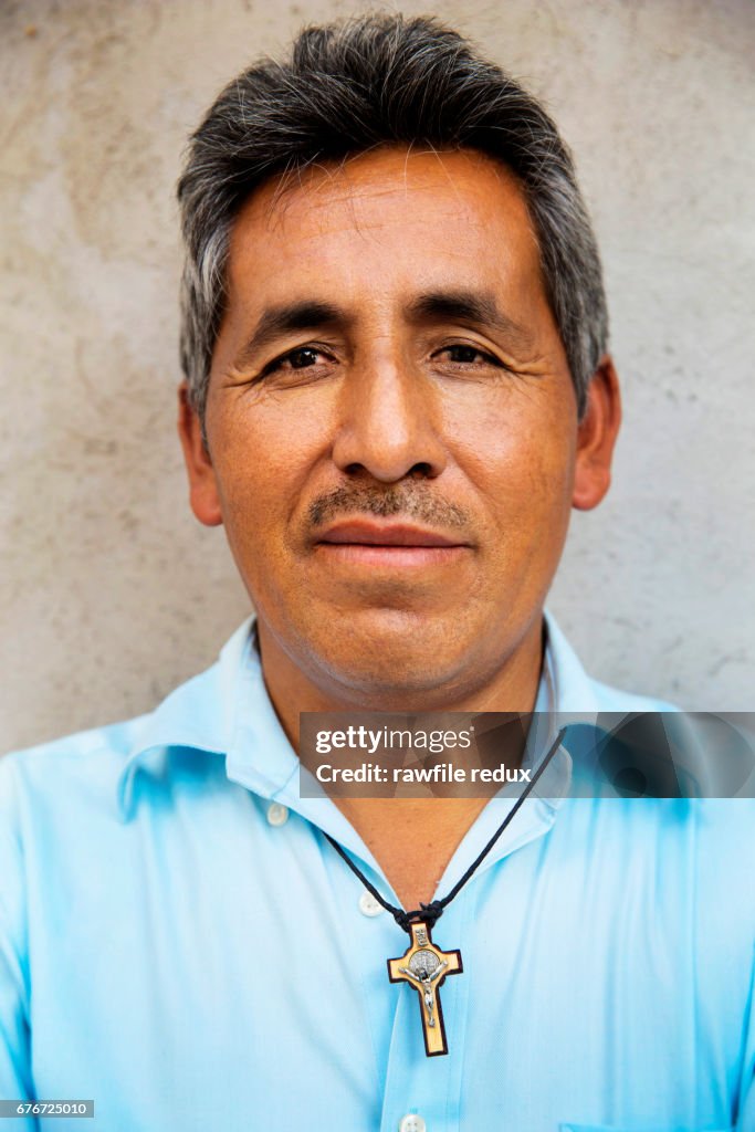 A MAN WITH A CRUCIFIX AROUND HIS NECK